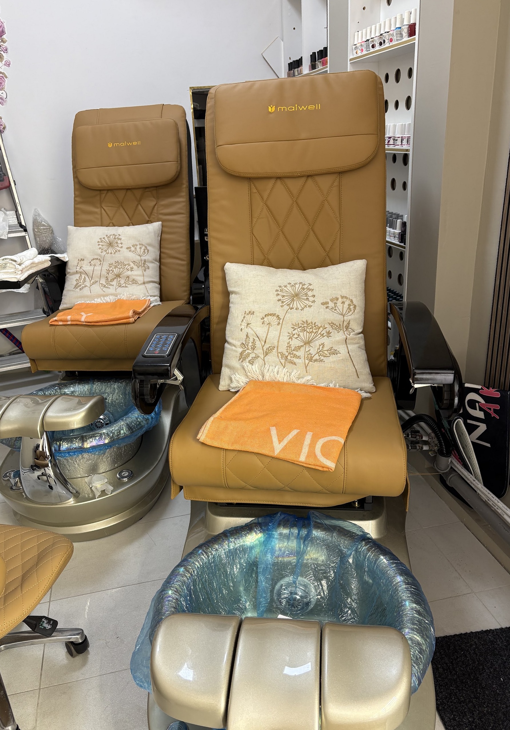 Twee pedicurestoelen met voetbaden en kussens in de studio